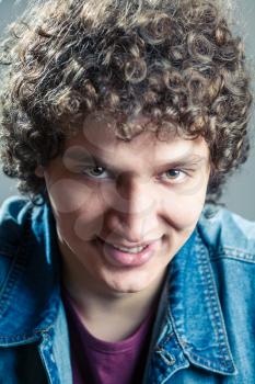 Smiling man closeup. Portrait of a young caucasian guy with curly hair