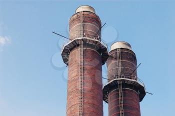 Two chimney-stalks against blue sky