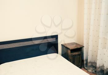 Colorized image of a part of a room with bed in a corner