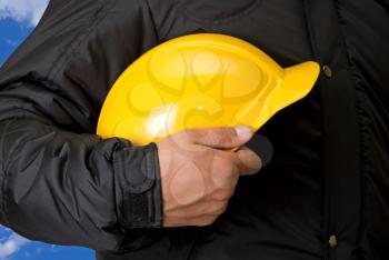 Royalty Free Photo of a Builder Holding a Yellow Hardhat 