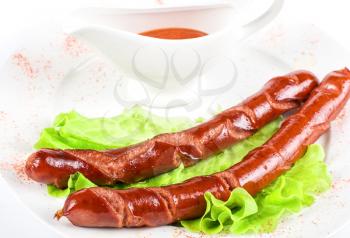 Royalty Free Photo of Grilled Sausage on Lettuce