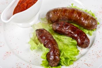 Royalty Free Photo of Grilled Venison Sausage With Sauce