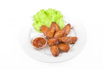 chicken roasted wing dish with sauce on a white background