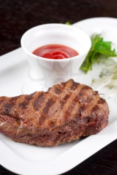 Juicy roasted beef steak with vegetables closeup at plate
