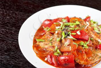 pork meat with tomato, pepper, prunes, garlic and green onion