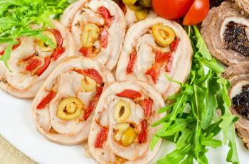 Cutting meat tenderloin with prune with lettuce, tomatoes and Ruccola