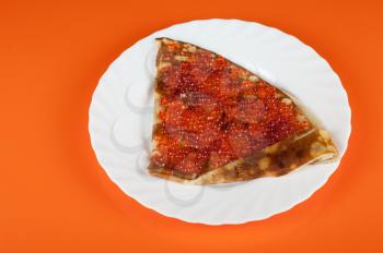 Pancake with red caviar closeup photo