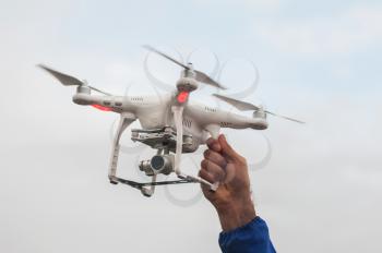 The flying drone copter with digital camera and human hand