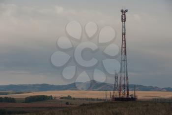 Telecommunications cell phone tower with antennas in a mountain location.