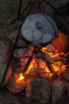 Preparing food on campfire in wild camping, resting on the nature