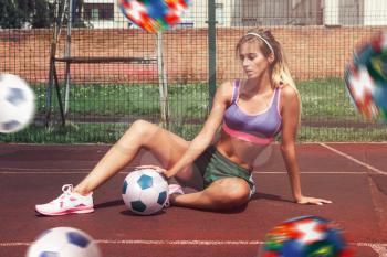 A young beauty athletic woman in sportswear with football ball outdoor. Concept of world soccer championship.