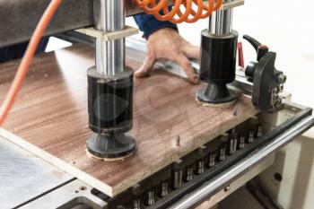 Furniture production concept: man working at machine and making furniture part