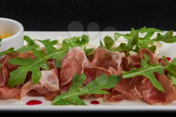 Famous Italian food Prosciutto with arugula closeup photo