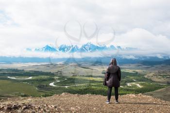 Woman watching to glacier in Altai mountains. Resting in mountains or global warming concept