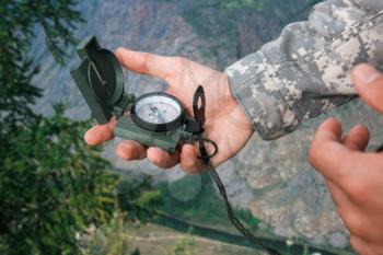 Man with compass in hand n Altai mountains. Travel concept.