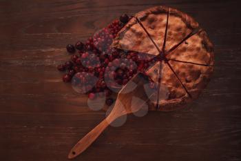 Berries pie with fresh berries and jam on vintage wooden background. Top view