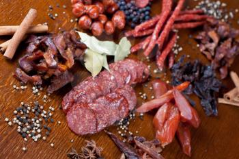 different sausage and meat on a celebratory table with spices and vegetables