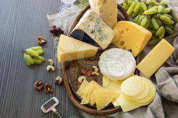 Various types of cheese set with grapes and nuts
