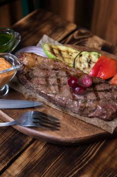 grilled beef steak with sauce and vegetables