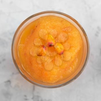 Sea buckthorn smoothie on a white concrete background. Square cropping