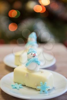 Christmas dessert with snowman on lights bokeh background