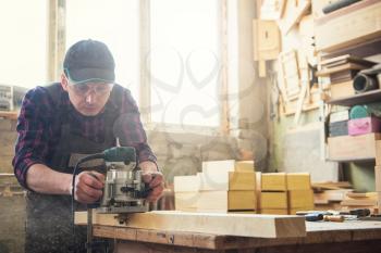 Worker grinds the wood box of angular grinding machine. Profession, carpentry and woodwork concept.
