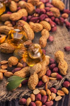 Natural peanuts with oil in a glass jar on the wooden background