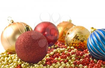 Christmas comes - colorful decoration baubles and beads over white