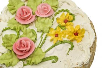 Close-up of tasty cake with cream, pink roses and green leaves