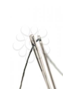 Macro of Two needles with thread over white