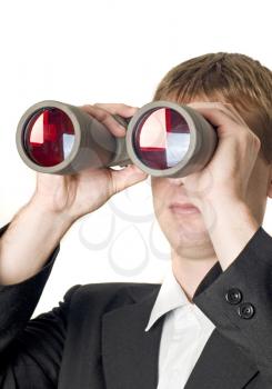 Businessman with binoculars searching for something isolated over white