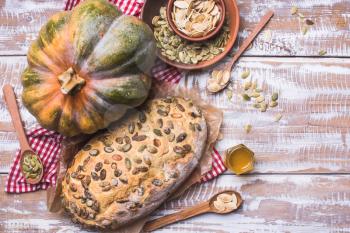 Newly baked white bread with seeds and pumpkin on wood. Rustic style food photo