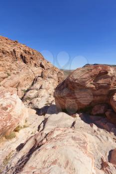 View of dry landscape and red rock formations of the Red Rock Canyon in the Mojave Desert.