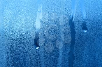 Frozen water drops on window glass closeup texture