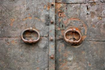 Old vintage metal door with ring handles and keyholes