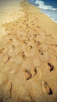 Footsteps in the sand at the beach - retro styled photo