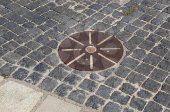 Cobblestones pavement with metal round detail. Decorative floor walkway in the park, Montjuic, Barcelona, Spain.
