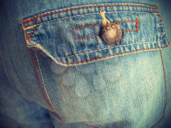 Fragment of close-up blue jeans with pockets, vintage effect background                               