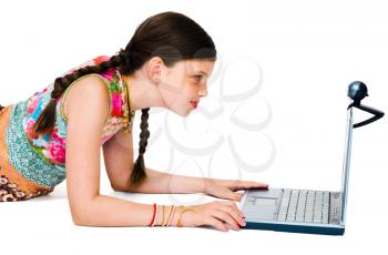 Royalty Free Photo of a Young girl Lying on the Floor Looking at her Laptop