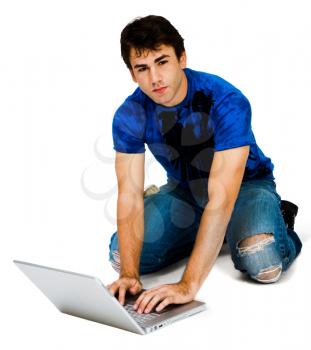 Royalty Free Photo of a Young Man on his Knees Using a Laptop