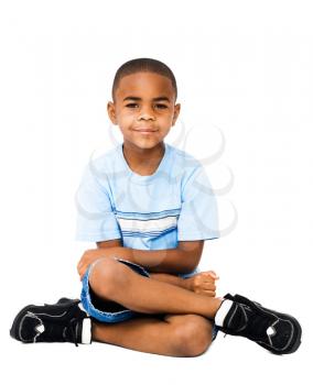 Smiling boy posing and sitting isolated over white