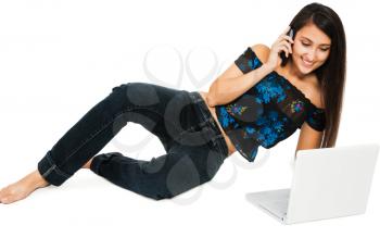 Smiling woman using a laptop and a mobile isolated over white