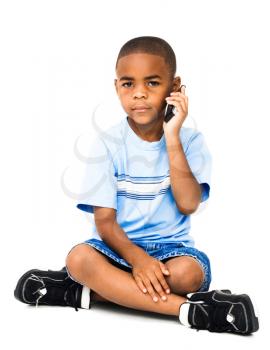 Boy talking on a mobile phone isolated over white