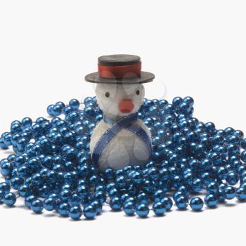 Close-up of a snowman on string of blue beads