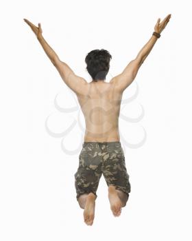 Rear view of a young man jumping with joy