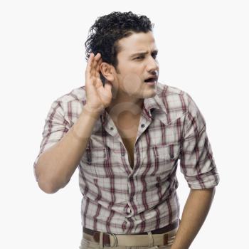 Man trying to listen with a cupped hand on his ear