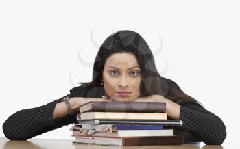 Portrait of a businesswoman resting her face on books