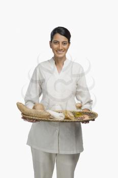 Woman holding a tray of products for aromatherapy