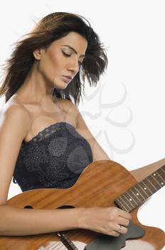 Close-up of a woman playing a guitar