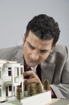 Businessman looking at a model home in an office